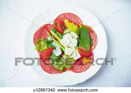 Stock Image - Mixed salad on slices salami, Differential Focus. Fotosearch