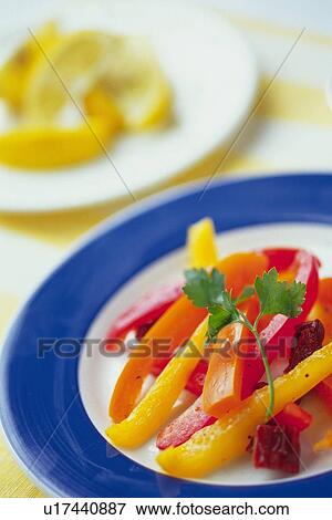 Stock Photo - Paprika slices on plate, other plate visible in background, Differential Focus. Fotosearch