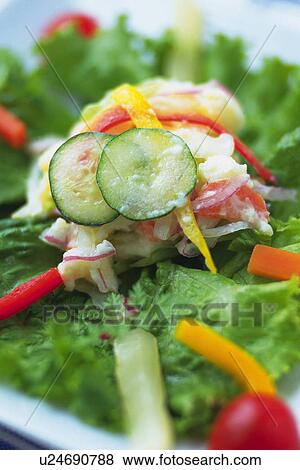 Stock Photo - Potato salad with leaf on plate, Differential Focus, Close Up. Fotosearch
