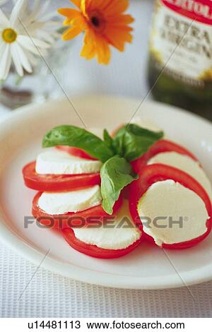 Salad of tomato slices with mozzarella, two flowers and oil bottle visible in background, close-up, Differential Focus View Large Photo Image Stock Image - Salad of tomato slices with mozzarella, two flowers and oil bottle visible in background, close-up, Differential Focus. Fotosearch