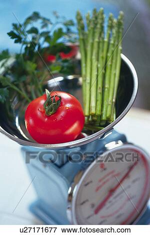 Tomato, leaves and asparagus on kitchen weighing scales, Differential Focus View Large Photo Image Stock Photo - Tomato, leaves and asparagus on kitchen weighing scales, Differential Focus. Fotosearch