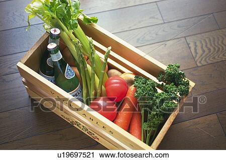 Stock Image - Various vegetables and two wine bottles in wooden box, Differential Focus . Fotosearch