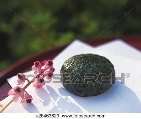Stock Photo - shi called Yomogimochi, Japanese sweet and flower on Japanese paper, Differential Focus. Fotosearch