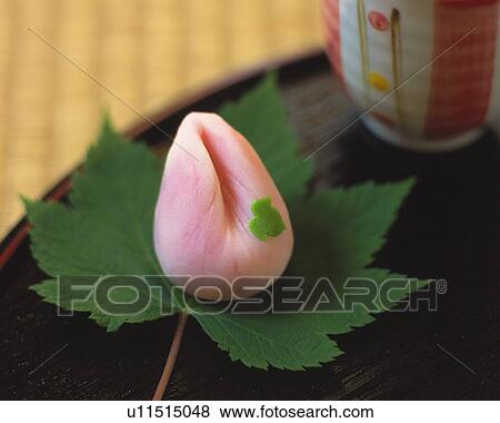 Stock Photo - shi, Japanese sweet on leaf, cup visible in background, Differential Focus. Fotosearch