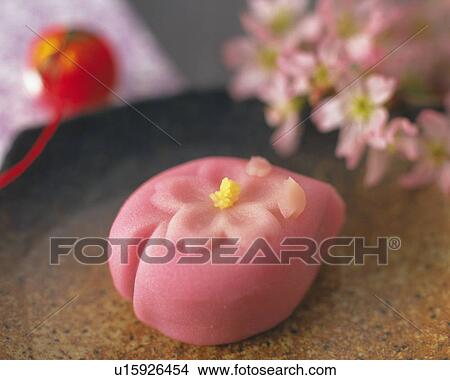 Picture - shi, Japanese sweet on tray, flowers and toy visible in background, Differential Focus, Close Up. Fotosearch