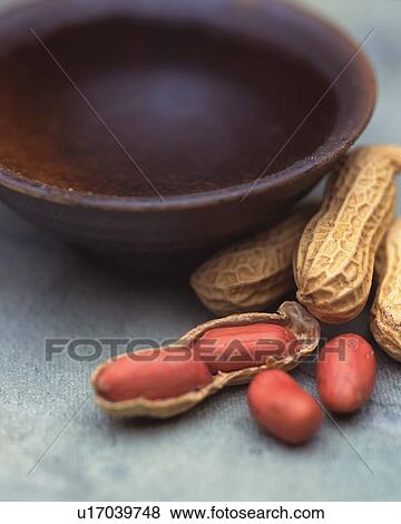 Stock Photo - Closed Up Image of a Little Bowl Filled With Sake and Several Peanuts Next to it. Fotosearch