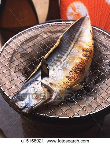 Stock Image - Closed Up Image of a Mackerel Being Grilled on a Traditional, Japanese Grill, High Angle View. Fotosearch