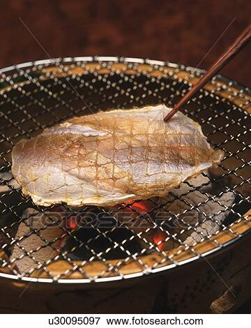 Stock Photo - Closed Up Image of a Piece of Threadsail Filefish Being Grilled, High Angle View. Fotosearch