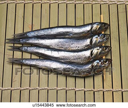 Stock Photography - Closed Up Image of Four Little Fish on a Bamboo Surface, High Angle View. Fotosearch