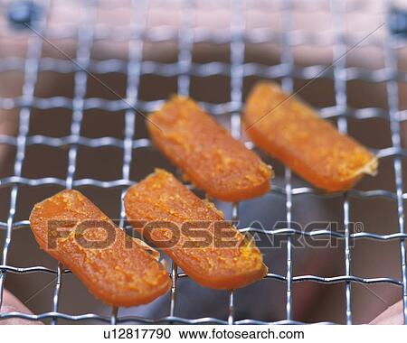 Stock Image - Closed Up Image of Four Little Pieces of Dried Pieces Being Grilled, High Angle View, Differential Focus. Fotosearch