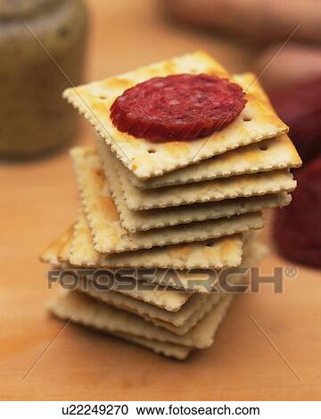 Stock Image - Closed Up Image of Several Crackers With a Slice of Salami on Top, Differential Focus. Fotosearch