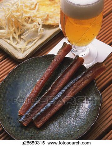 Closed Up Image of Several Japanese Snacks, Such as Dried Squid Next to a Glass of Beer, High Angle View View Large Photo Image Stock Photography - Closed Up Image of Several Japanese Snacks, Such as Dried Squid Next to a Glass of Beer, High Angle View. Fotosearch