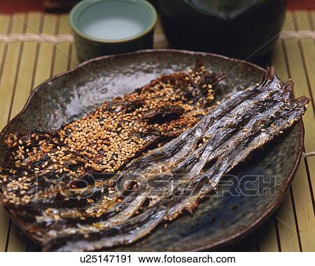 Stock Image - Closed Up Image of Several Pieces of Pickled Fish and Some Sake, High Angle View. Fotosearch