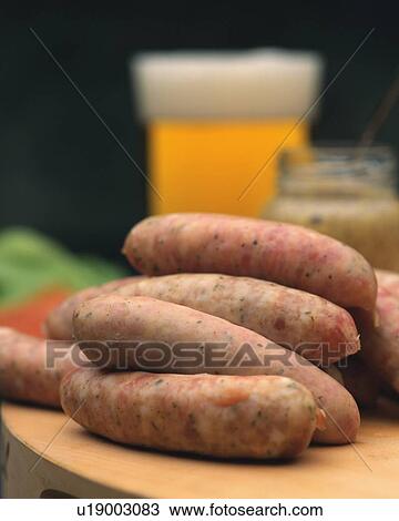 Stock Image - Closed Up Image of Several Sausages, Some Mustard and a Glass of Beer, Differential Focus. Fotosearch
