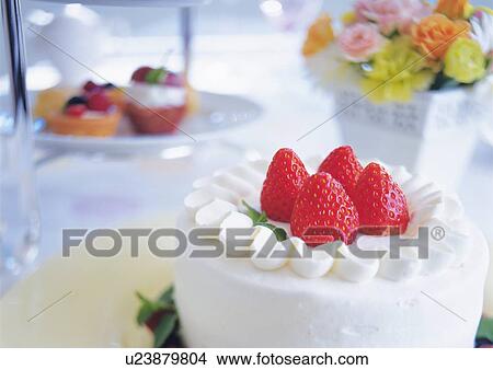 Picture - Strawberry cake and flowers on table. Fotosearch