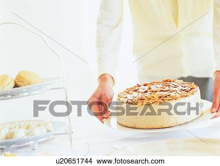 Picture - Woman holding a plate with cake. Fotosearch