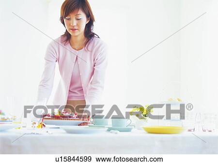 Young woman arranging table View Large Photo Image Stock Photo - Young woman arranging table. Fotosearch