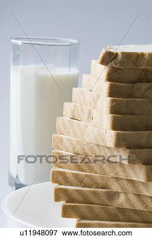 Stock Photo - Close-up of a stack of bread with a glass of milk. Fotosearch