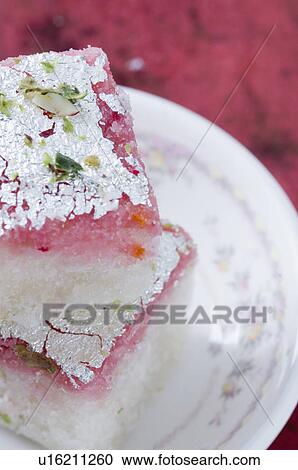 Stock Image - Close-up of a stack of Burfi in a saucer. Fotosearch
