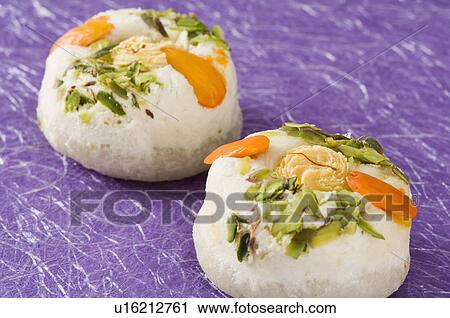 Stock Image - Close-up of Bengali sweet garnished with Almond and Pistachio. Fotosearch