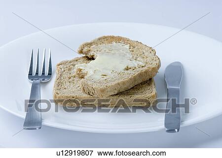 Close-up of brown bread and butter on a plate View Large Photo Image Stock Photo - Close-up of brown bread and butter on a plate. Fotosearch