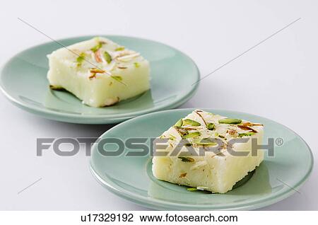 Stock Image - Close-up of Burfi in saucers. Fotosearch