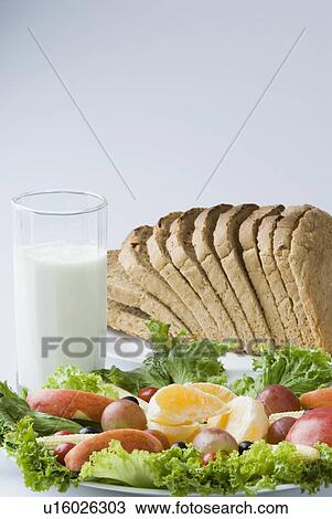 Close-up of fruits and vegetables in a plate with a glass of milk View Large Photo Image Stock Image - Close-up of fruits and vegetables in a plate with a glass of milk. Fotosearch