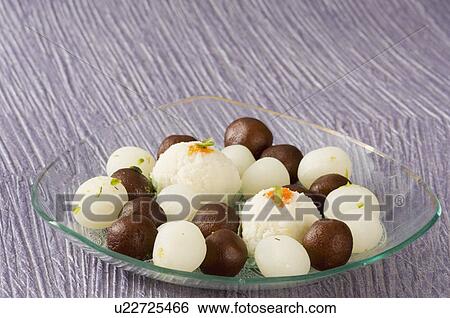 Stock Photograph - Close-up of Rasgullas and Gulab Jamuns in a bowl. Fotosearch