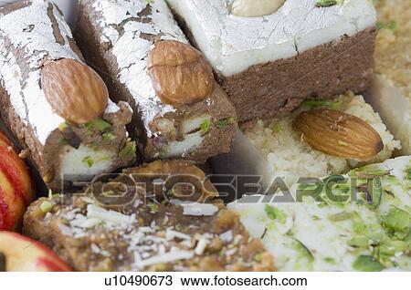 Stock Image - Close-up of sweets garnished with Almonds and Pistachio. Fotosearch