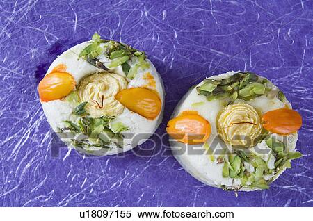 Stock Photography - High angle view of Bengali sweets garnished with Almonds and Pistachio. Fotosearch