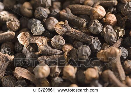 Stock Image - Close-up of cloves and black peppercorns. Fotosearch