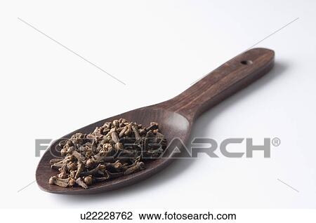 Stock Image - Close-up of cloves in a wooden spoon. Fotosearch