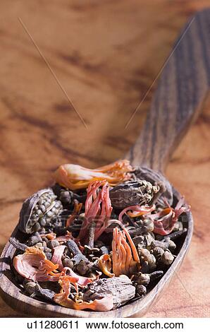 Stock Image - Close-up of spices in a wooden spoon. Fotosearch