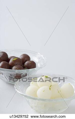 Stock Image - Rasgullas and Gulab Jamuns in two bowls. Fotosearch