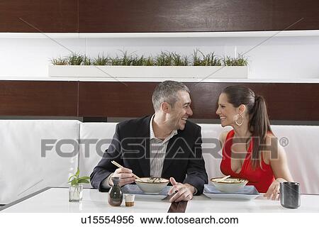 Couple eating noodles in restaurant View Large Photo Image Stock Photograph - Couple eating noodles in restaurant. Fotosearch