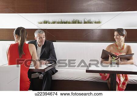 Picture - Man with girlfriend flirting with other woman. Fotosearch