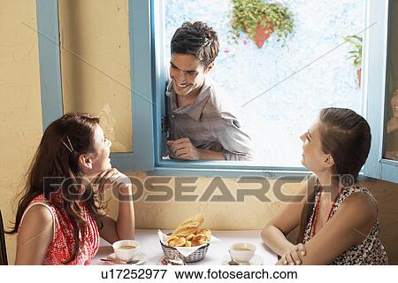 Stock Photo - Two women talking to man at window. Fotosearch