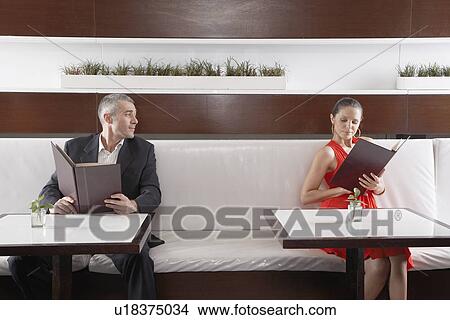 Woman and man with menus flirting View Large Photo Image Picture - Woman and man with menus flirting. Fotosearch