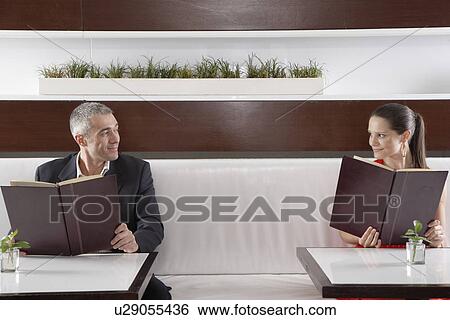 Stock Photograph - Woman and man with menus flirting. Fotosearch