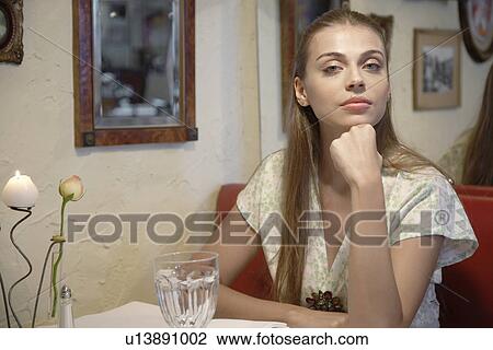 Stock Image - Woman at dining table (portrait). Fotosearch
