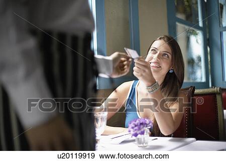 Woman giving credit card to waiter View Large Photo Image Stock Photo - Woman giving credit card to waiter. Fotosearch