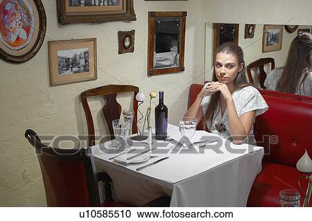 Woman sitting at dining table in restaurant View Large Photo Image Stock Image - Woman sitting at dining table in restaurant. Fotosearch