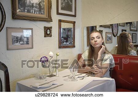 Picture - Woman waiting at table in restaurant. Fotosearch