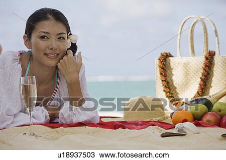 A young woman lying on beach looking away View Large Photo Image Stock Image - A young woman lying on beach looking away. Fotosearch