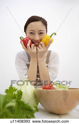 Portrait of a woman holding bell peppers View Large Photo Image Stock Image - Portrait of a woman holding bell peppers. Fotosearch