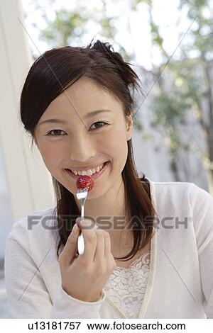 Portrait of a young woman eating strawberry View Large Photo Image Stock Photo - Portrait of a young woman eating strawberry. Fotosearch