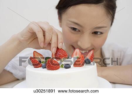 View of a young woman garnishing a pastry View Large Photo Image Stock Image - View of a young woman garnishing a pastry. Fotosearch
