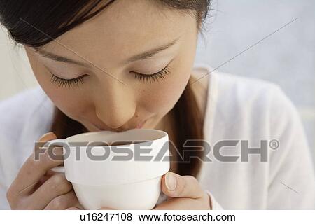View of a young woman having beverage View Large Photo Image Stock Photo - View of a young woman having beverage. Fotosearch
