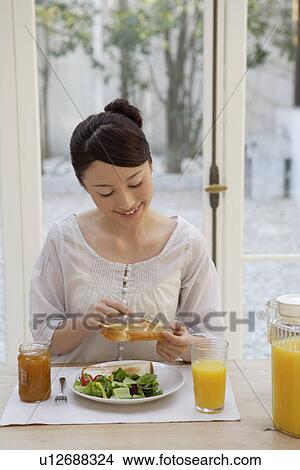 View of a young woman having breakfast View Large Photo Image Picture - View of a young woman having breakfast. Fotosearch