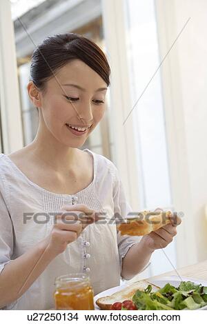 View of a young woman having breakfast View Large Photo Image Picture - View of a young woman having breakfast. Fotosearch
